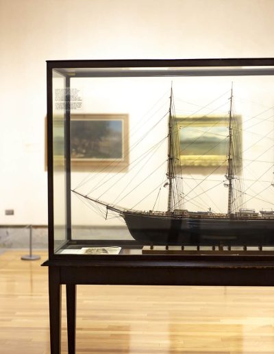 A model of a large sailing ship is displayed inside the museum exhibit.