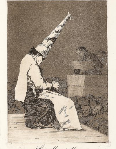 Etching of a man sitting down on a stage and wearing a tall dunce cap with his hands clasped together on his lap while a crowd of people watch on from below the stage. In the distance is a man standing at a podium and reading from a book. It appears the man on stage is being humiliated.