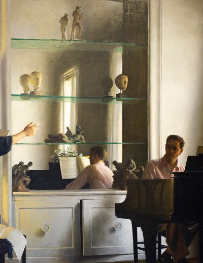 A man sits in front a piano while listening to woman across the room who is pointing towards him and reading aloud from a book.
